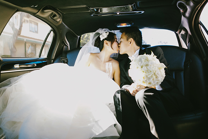 bride and groom kissing in a limo